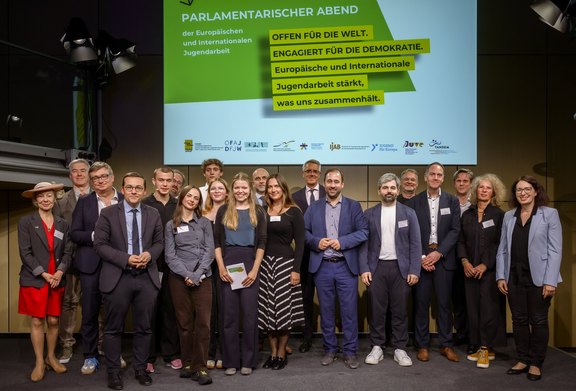 Gruppenbild der Teilnehmer:innen des 11. Parlamentarischen Abends der Europäischen und Internationalen Jugendarbeit auf der Bühne.