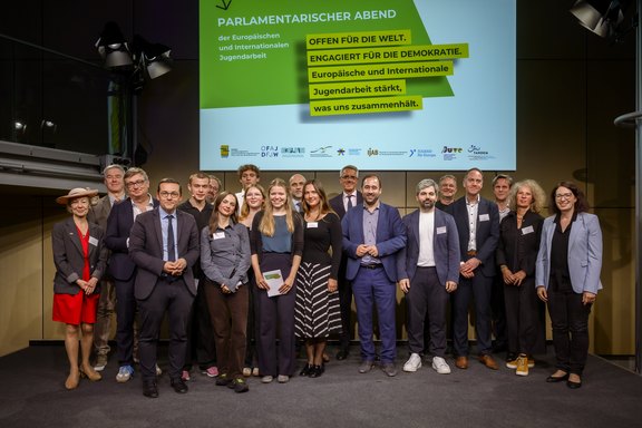 Gruppenbild der Teilnehmer:innen des 11. Parlamentarischen Abends der Europäischen und Internationalen Jugendarbeit auf der Bühne.