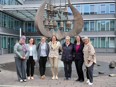 Sieben Frauen stehen vor dem Gebäude des Bildungsministeriums von Rheinland-Pfalz.