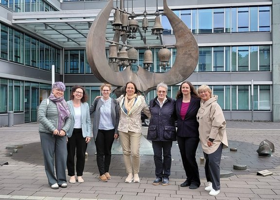 Sieben Frauen stehen vor dem Gebäude des Bildungsministeriums von Rheinland-Pfalz.