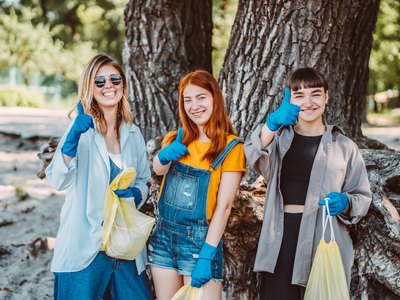 Jugendliche sammeln mit Handschuhen Müll für den Umweltschutz
