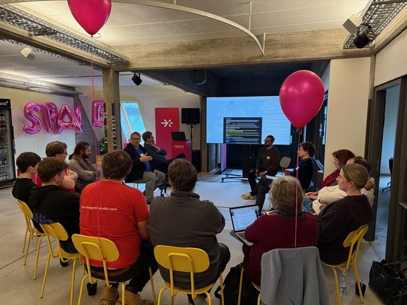 Ein Gruppe Teilnehmender diskutiert mit dem Referenten