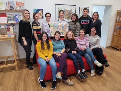 Die Gutachterin von ConFlex überreicht den Kunstdruck an die Tandem-Mitarbeiter:innen.