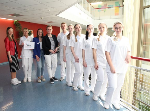 Junge Pflegekräfte stehen in einer Reihe