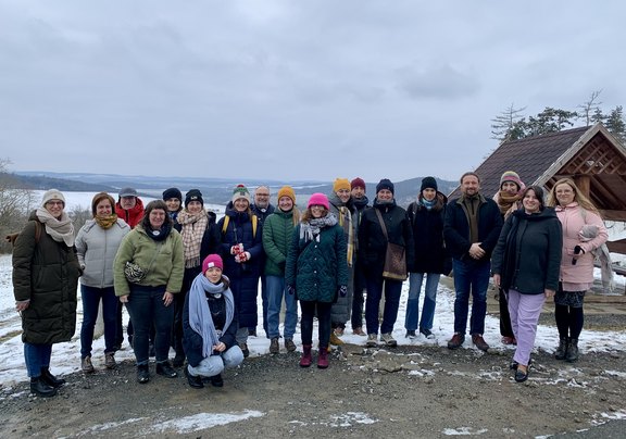 Personengruppe steht in einer Winterlandschaft