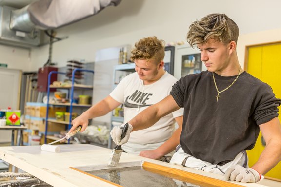 Auszubildende beim Streichen einer Tür