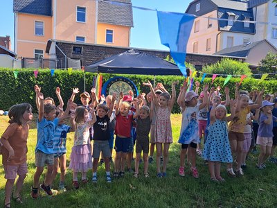 Lachende Kindergruppe auf einer Wiese